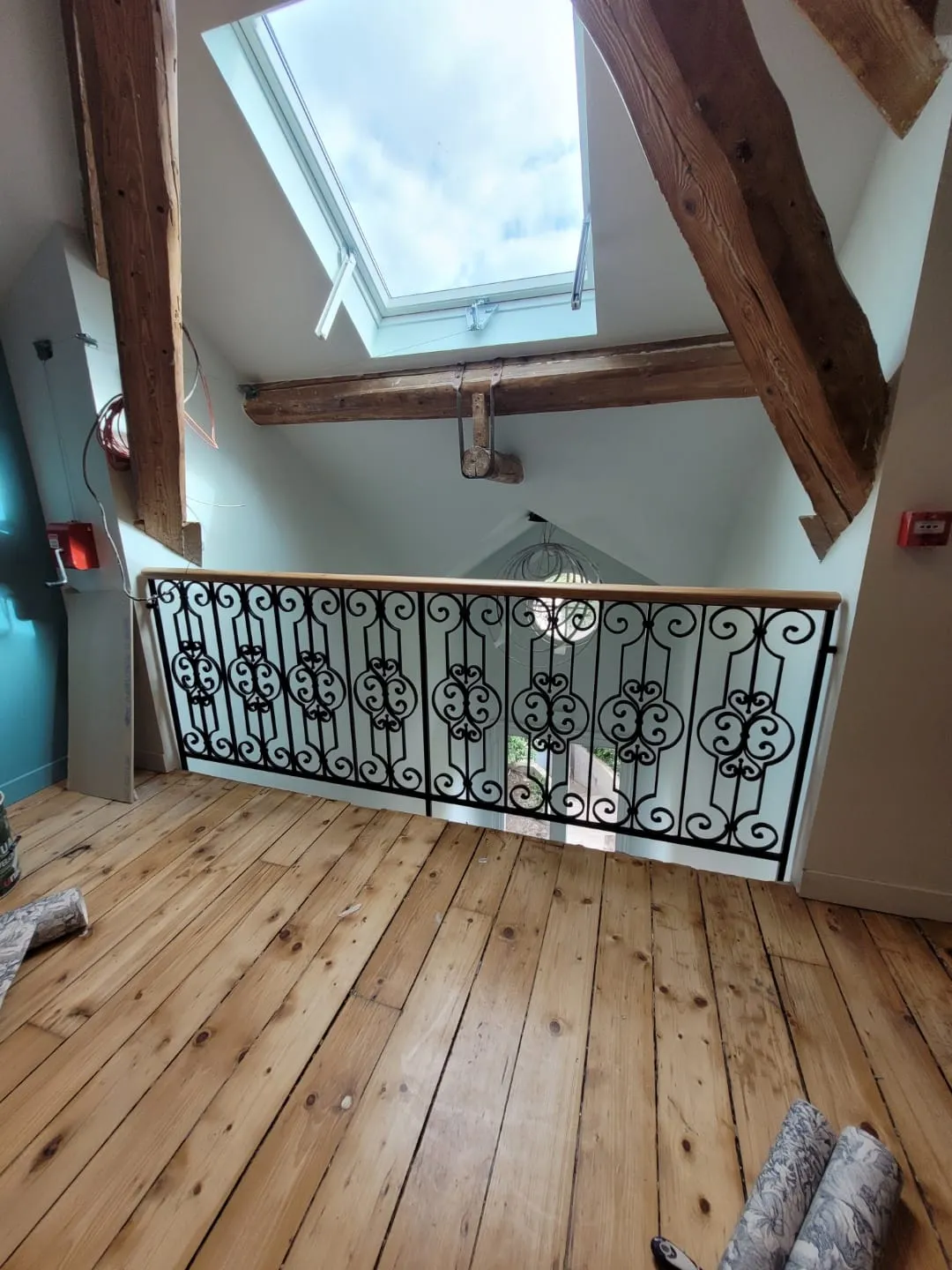 Garde-corps fer forgé noir avec rinceaux sur palier de comble
