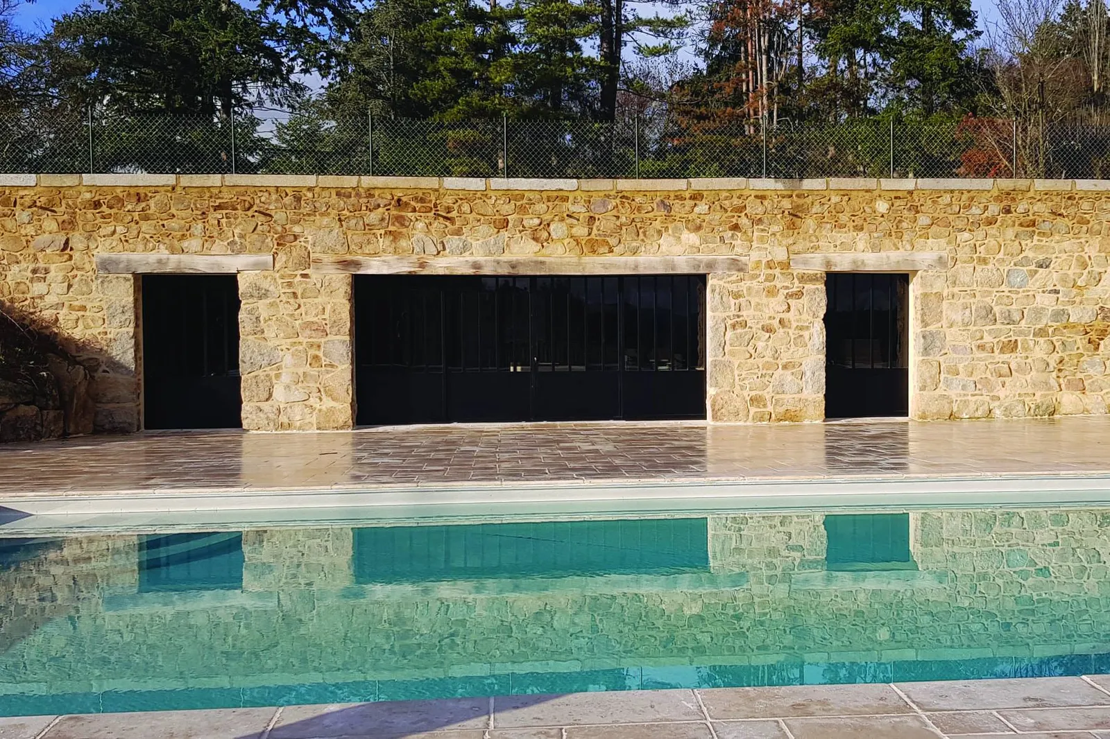 Portail métal noir accès piscine muret pierre