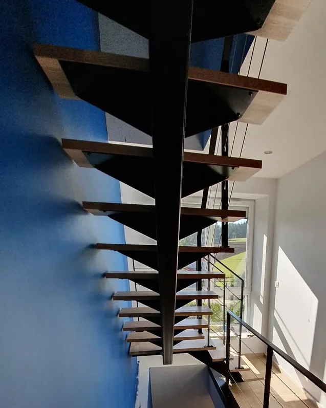 Escalier suspendu à limon central acier et marches en bois massif, garde-corps acier à câbles — réalisation MDS